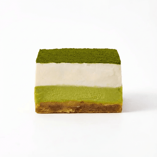 Matcha Yuzu dessert slice with green matcha powder, creamy layers, and a brown crust on a white background