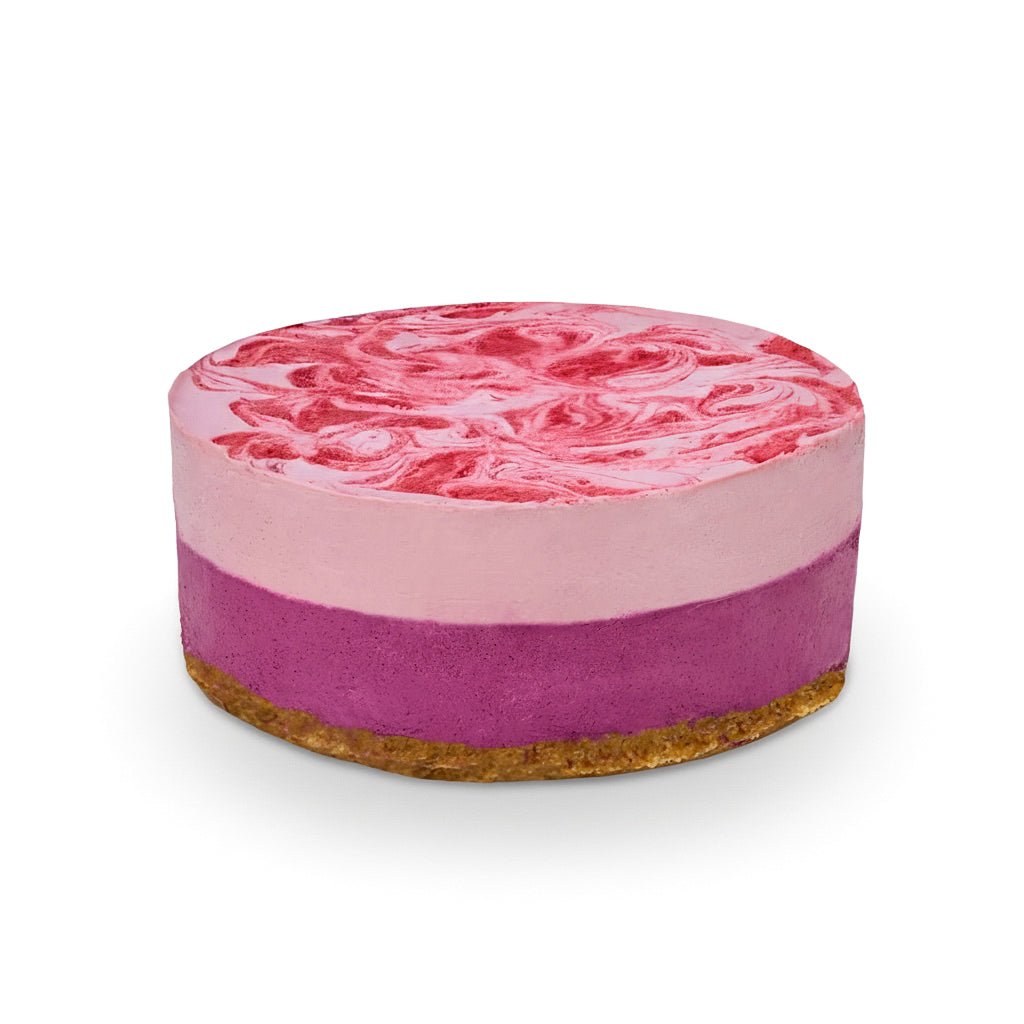 Berry round layered cake with pink swirled top and purple middle layer on a brown crust base