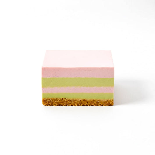 Square layered cake slice with pink and green layers and a crumbly brown base named Strawberry Basil