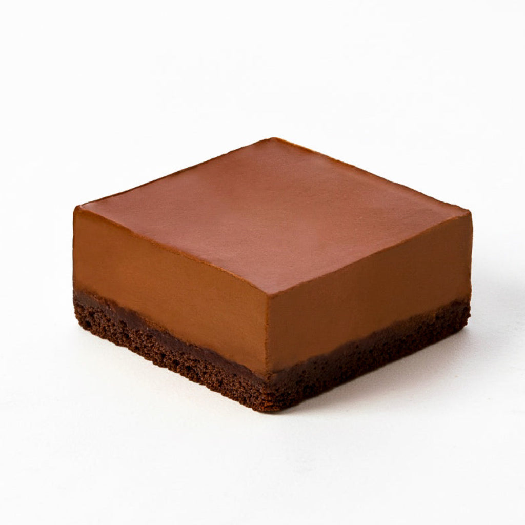 Square rich Chocolate dessert with smooth top layer and dense chocolate base on white background